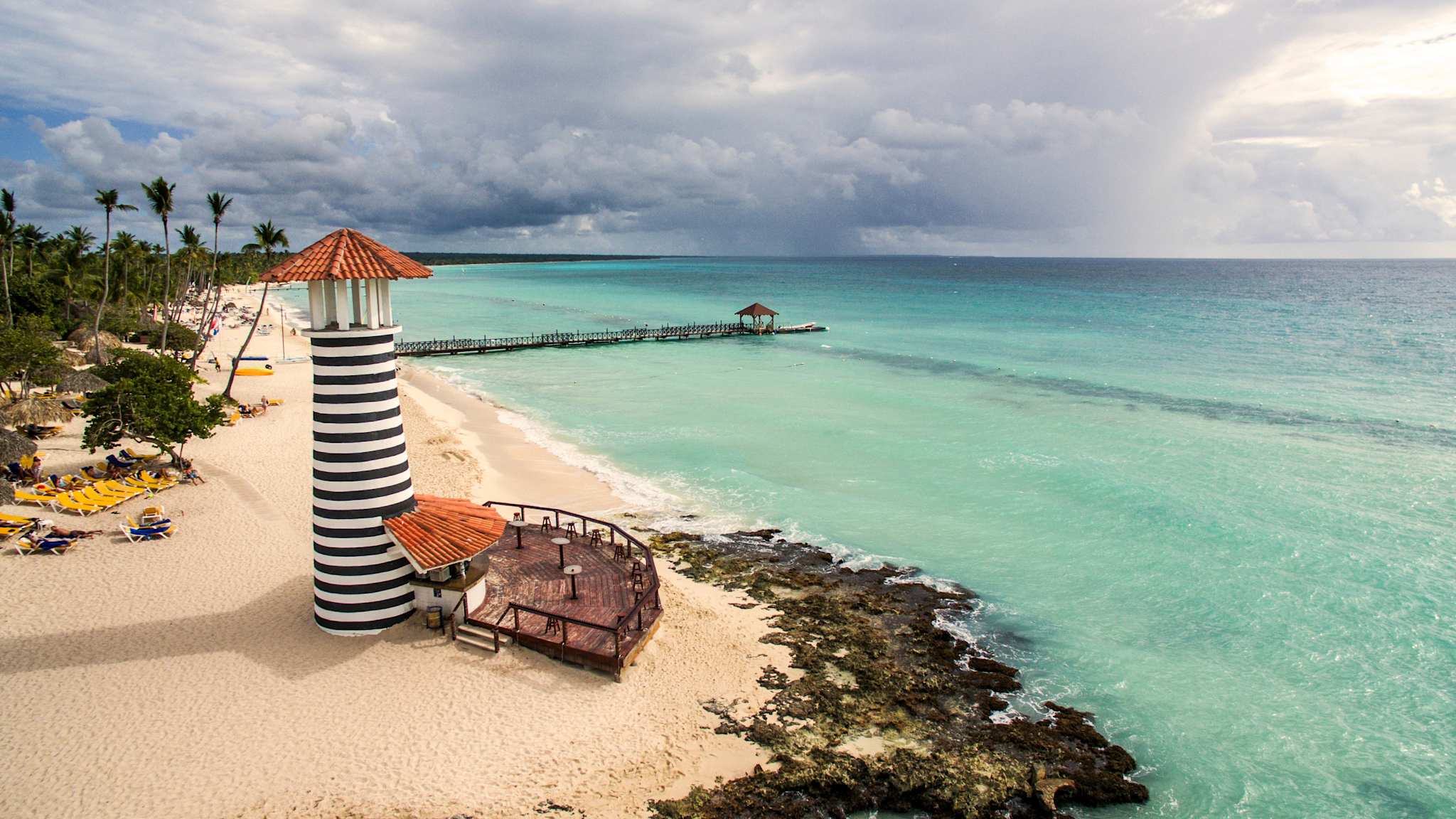 Ein Strand mit einem gestreiften Leuchtturm